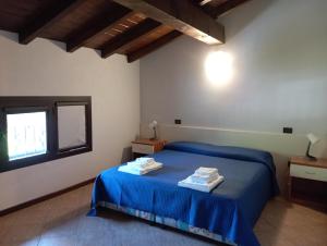 a bedroom with a blue bed with towels on it at Mulinaccio Appartamenti in Pievepelago
