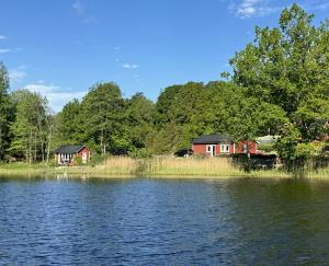 a couple of houses on the shore of a lake at Lake House Rågeboda in Södra Rågeboda