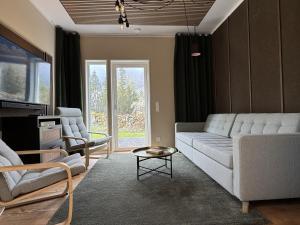a living room with a couch and two chairs at Lake House Rågeboda in Södra Rågeboda