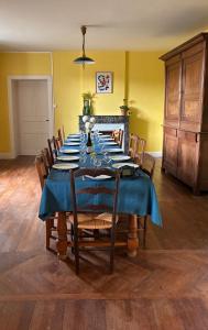 a dining room with a blue table and chairs at La maison des ponts in Pont-sur-Madon +19 photos