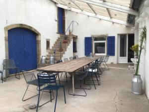 a long wooden table and chairs in front of a building at La maison des ponts in Pont-sur-Madon