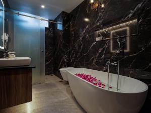 a bathroom with a bath tub and a sink at Solar Residency, Srinagar in Srinagar +85 photos