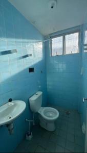 a blue bathroom with a toilet and a sink at AbaHome Paiva in Cabo de Santo Agostinho