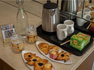 a counter with three plates of pastries and jars of jam at Solar Residency, Srinagar in Srinagar