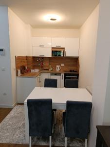 a kitchen with a white table and chairs at Virgin Forest D&A in Gornja Presjenica
