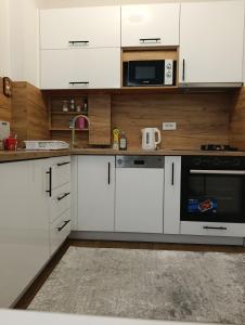 a kitchen with white cabinets and a microwave at Virgin Forest D&A in Gornja Presjenica +12 photos