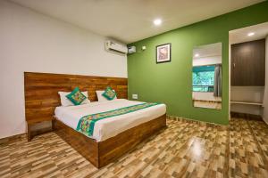 a bedroom with a bed and a green wall at Treebo Lands End Beach Resort - 100m From Morjim Beach in Morjim +17 photos