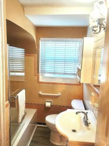 a bathroom with a toilet and a sink and a window at 513Company - Hometown +Location in Cincinnati +8 photos