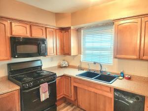 a kitchen with wooden cabinets and a stove and a sink at 513Company - Hometown +Location in Cincinnati