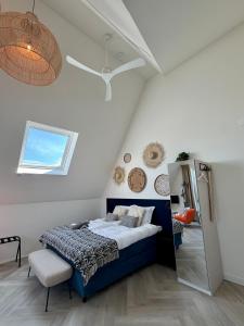 a bedroom with a blue bed and a mirror at Mel's Pintxos winebar & Aparthotel in Zandvoort