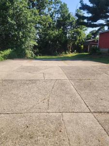an empty parking lot with trees and a red barn at 513Company - Hometown +Location in Cincinnati