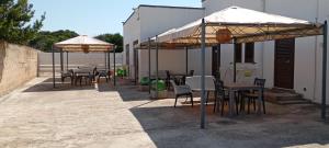 a group of tables and chairs under umbrellas at Villa Saponaro - Affittacamere in Torre Lapillo