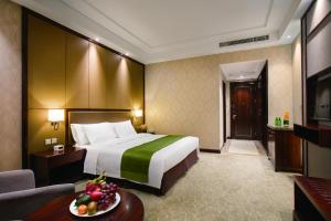 um quarto de hotel com uma cama grande e uma mesa em Holiday Inn Beijing Airport Zone, an IHG Hotel em Shunyi