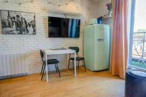 a room with a table and a refrigerator and a television at Antony City Center Studio AC in Antony