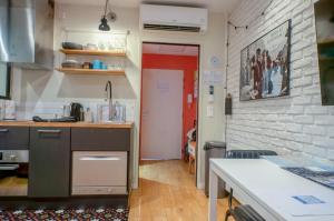 a kitchen with a counter and a red door at Antony City Center Studio AC in Antony