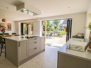 a kitchen with a large island and a dining room at Cern-Wyn in Chippenham