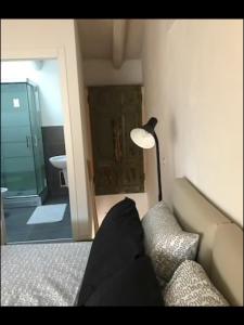 een kamer met een bank, een lamp en een badkamer bij Antonella Gardalake 2 in Desenzano del Garda