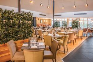 a restaurant with tables and chairs and plants at De Vere Wokefield Estate in Reading