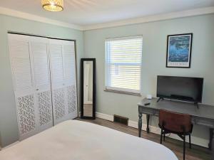 a bedroom with a bed and a desk and a television at 513Company - Sanctuary in Cincinnati
