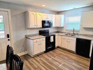 a kitchen with white cabinets and black appliances at 513Company - Sanctuary in Cincinnati