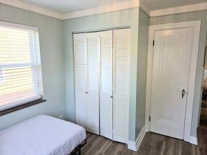 a bedroom with a white bed and a closet at 513Company - Sanctuary in Cincinnati