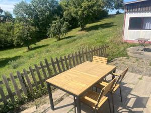 a wooden table and chair next to a fence at wiesenhimmel cozy, Tiny house with sauna in Forchtenberg