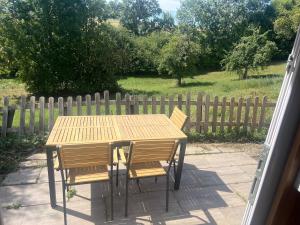 a wooden table and chairs with a wooden fence at wiesenhimmel cozy, Tiny house with sauna in Forchtenberg
