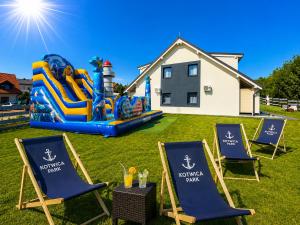 a group of lawn chairs and a water park at Domki Kotwica PARK Władysławowo - 3 Podgrzewane Baseny pod Kopułą in Władysławowo