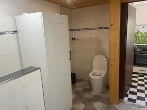 a small bathroom with a toilet and a refrigerator at wiesenhimmel cozy, Tiny house with sauna in Forchtenberg +3 photos
