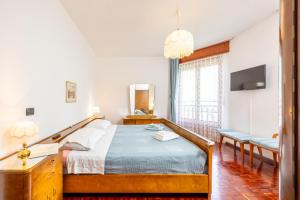 a bedroom with a bed and a tv and a window at Casa Lena in Colorina