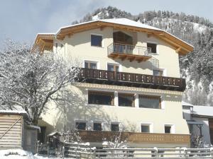 a large building with a balcony in the snow at Hotel Chavalatsch in Tubre