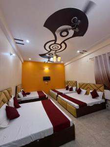 a hotel room with two beds and a ceiling fan at Hotel New Vedas Villa 15 mints From Ram Temple in Ayodhya