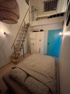 a room with a bed and a blue door and stairs at Tomorrowland Boom in Boom
