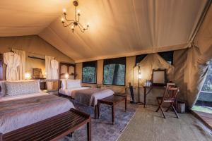 a bedroom with two beds in a tent at Elephant Pepper Camp in Masai Mara