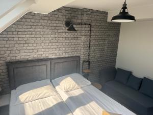 a bedroom with a bed and a brick wall at Guest Apartments Orłowo in Gdynia
