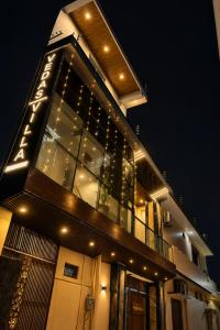 a building with lights on the side of it at night at Hotel New Vedas Villa 15 mints From Ram Temple in Ayodhya
