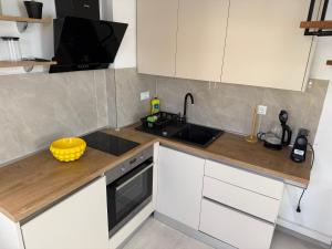 a kitchen with white cabinets and a sink at House Marin - by the beach in Igrane