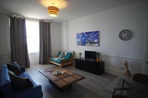 a living room with a couch and a coffee table at Ground floor sea view flat Hastings in Hastings