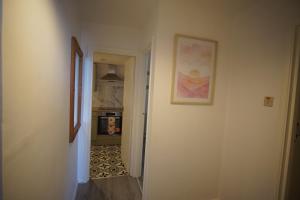 a hallway leading to a kitchen with a painting on the wall at Ground floor sea view flat Hastings in Hastings