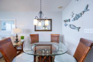 a dining room with a glass table and chairs at Phoenix VII 7709 condo in Orange Beach