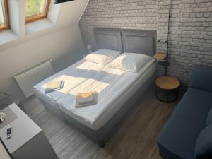 a bedroom with a bed and a brick wall at Guest Apartments Orłowo in Gdynia