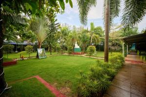 a garden with a statue in the middle of it at Treebo Lands End Beach Resort - 100m From Morjim Beach in Morjim