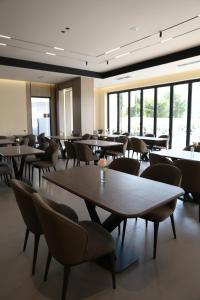 a dining room with tables and chairs and windows at Hotel Roden in Golem +47 photos