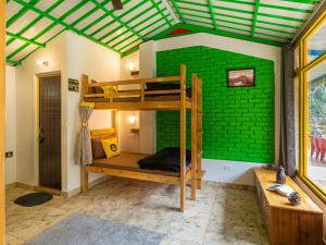 a room with a bunk bed and a green wall at The Hosteller Mussoorie By the Streamside, Kempty in Mussoorie +31 photos