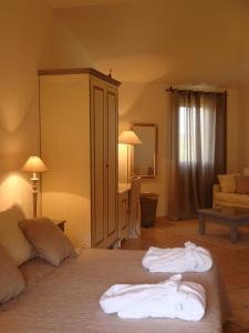 a bedroom with a bed with two towels on it at Relais Fenicottero Rosa in Porto San Paolo