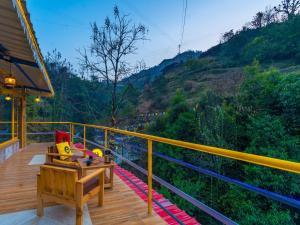 a balcony of a house with a view of a mountain at The Hosteller Mussoorie By the Streamside, Kempty in Mussoorie