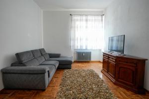 a living room with a couch and a tv at Casa di Caterina in Cuneo