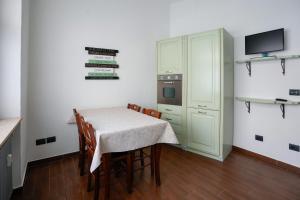 a kitchen with a table with chairs and a television at Casa di Caterina in Cuneo