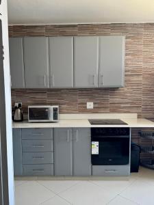 a kitchen with white cabinets and a counter top at Afsaal 612 in Amanzimtoti +8 photos