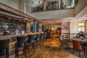 a bar in a restaurant with people sitting at tables at The Three Swans Hotel, Market Harborough, Leicestershire - The Coaching Inn Group in Market Harborough